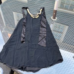 Black lined Alice and Olivia halter dress with gold details and a scooped back.